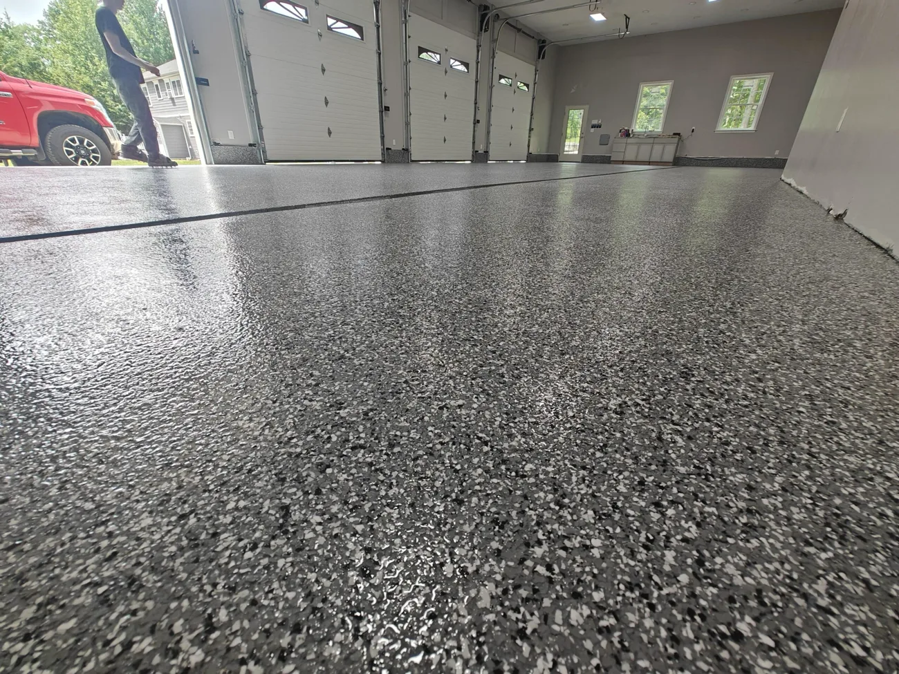 Full-broadcast flake epoxy floor across a multi-bay garage