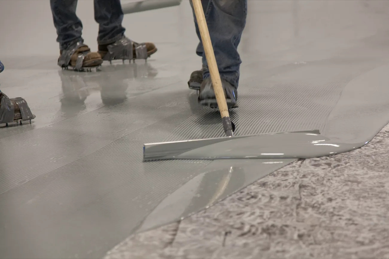 Epoxy floor coating being spread with a squeegee