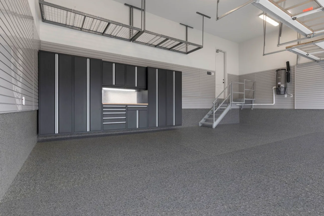 Gray flake garage floor coating with cabinets and overhead storage